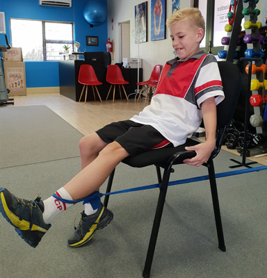 Young boy doing leg extensions